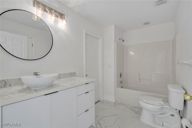 Full bathroom featuring marble finish flooring, tu