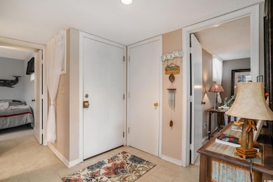 Entryway with light tile patterned floors and baseboards