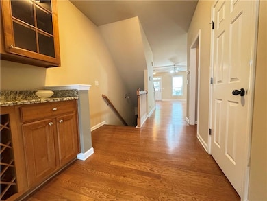 Hallway featuring an upstairs landing, wood finish