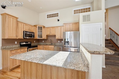 Kitchen featuring light brown cabinetry, visible v