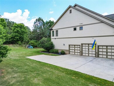 View of side of home with a lawn, driveway, and an attached garage