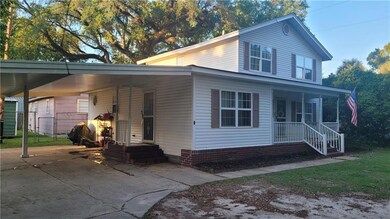 View of front of home with covered porch and a car