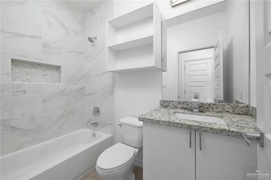 Full bathroom featuring tile floors, vanity, toilet, and tiled shower / bath combo