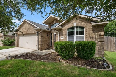 View of front facade with a garage, driveway, and brick siding