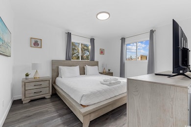 Bedroom featuring wood finished floors and baseboards