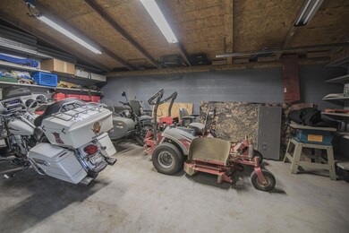 6th bay of garage that can be closed off from main garage, seller uses as a storm shelter. 