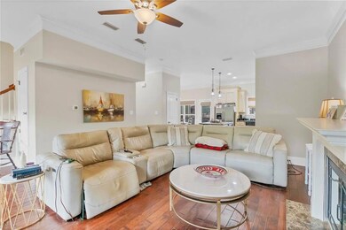 Living room with ceiling fan, hardwood / wood-style flooring, ornamental molding, recessed lighting, and baseboards