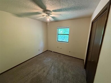 Unfurnished bedroom with a textured ceiling, carpe