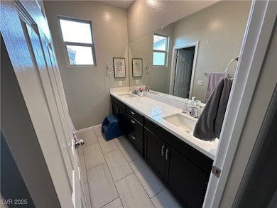Bathroom featuring a sink, baseboards, and double