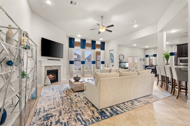 Gather the family and guests together in your lovely living room! Featuring high ceilings, recessed lighting, dark stained ceiling fan, custom paint, gorgeous tile floors, fireplace with mantel and large windows that provide plenty of natural lighting throughout the day.