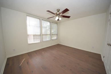 Empty room featuring ceiling fan and wood-type flooring