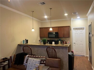 Kitchen with light stone countertops, black applia