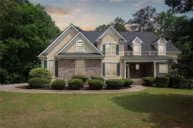 View of front of home with a lawn, stone siding, a