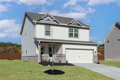 View of front of home featuring a garage, a front lawn, and board and batten siding