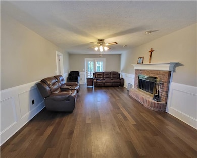 Living area featuring a textured ceiling, a firepl