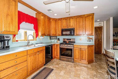 Cabinet filled eat in kitchen with under cabinet and recessed lighting above.