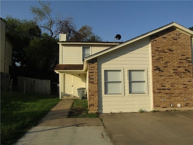 View of side of home featuring a chimney, brick siding, and a porch