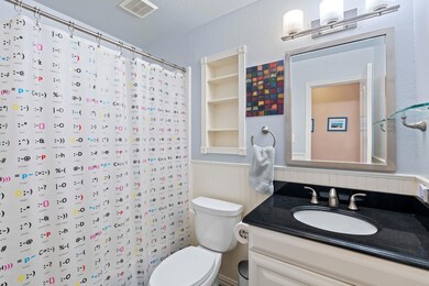 Full bath featuring a wainscoted wall, toilet, va