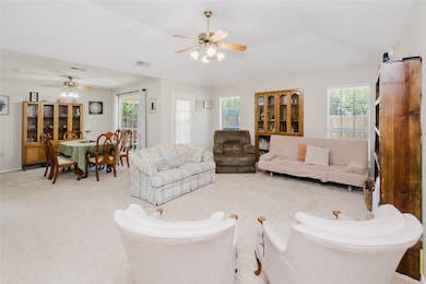 Living room with vaulted ceilings, built-ins, and big windows.