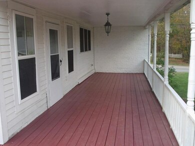 The covered porch with the door on...