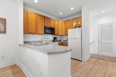 Kitchen with kitchen peninsula, sink, white applia