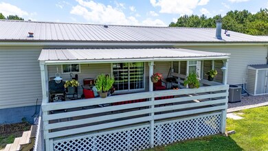 Rear view of house with a metal roof and a sunroom