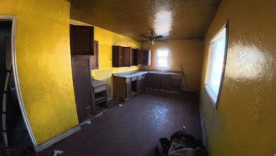 Kitchen featuring a textured wall, a textured ceiling, a ceiling fan, and dark brown cabinets
