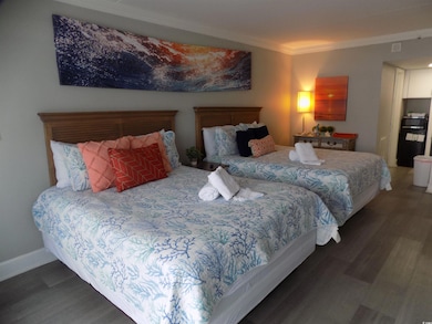 Bedroom featuring crown molding and wood finished floors