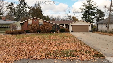 Ranch-style home with driveway, an attached garage, and brick siding