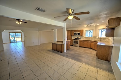 Kitchen with open floor plan, plenty of natural light, and a ceiling fan