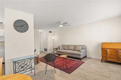 Living room with light wood-style floors and a ceiling fan