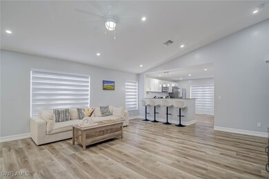 Living room with lofted ceiling, ceiling fan, ligh