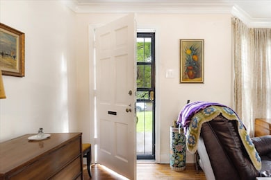 Foyer featuring crown molding and wood finished floors