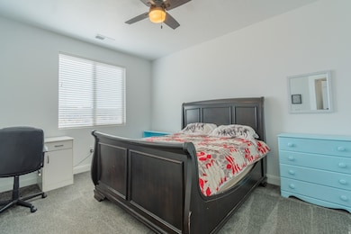 Bedroom featuring light colored carpet and a ceiling fan