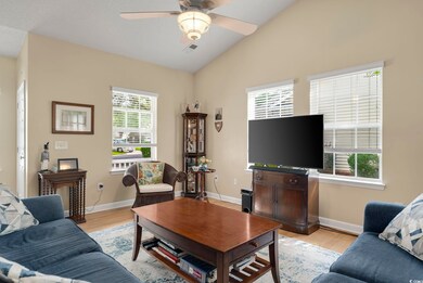Living room featuring ceiling fan, vaulted ceiling