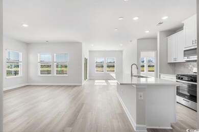 Kitchen featuring a center island with sink, light