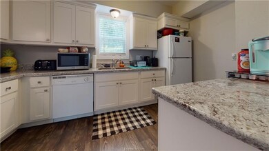 Kitchen with dark wood-style floors, white applian