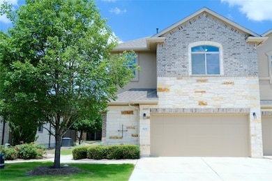View of front of home featuring stone siding, a g