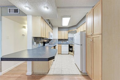 Kitchen with light brown cabinets, white applianc