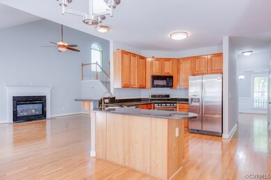 Open concept kitchen opens to living room with vau