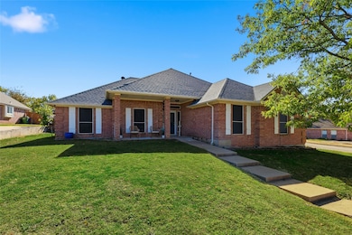 Ranch-style house with roof with shingles, brick siding, and a front yard