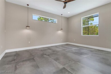 Empty room featuring ceiling fan, concrete floorin
