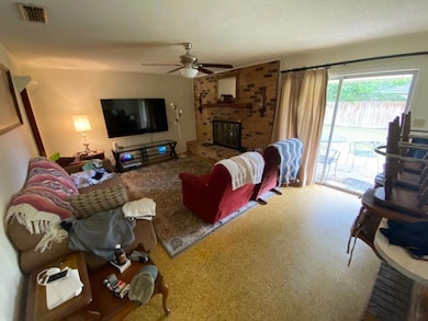 Living area featuring a brick fireplace, a ceiling