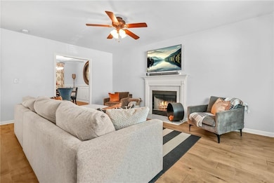 Living area with ceiling fan, a fireplace with flu