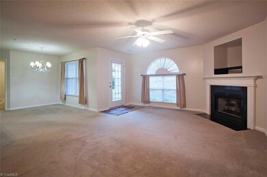 Large spacious living room  with fireplace and entrance to the patio