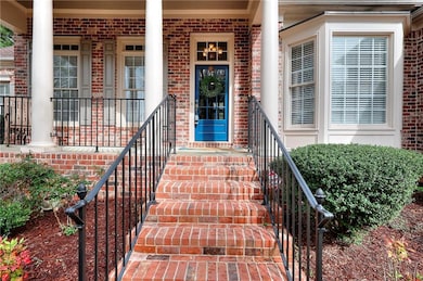 View of exterior entry with covered porch and bric