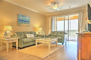 Living room featuring light wood-type flooring, crown molding, and a ceiling fan