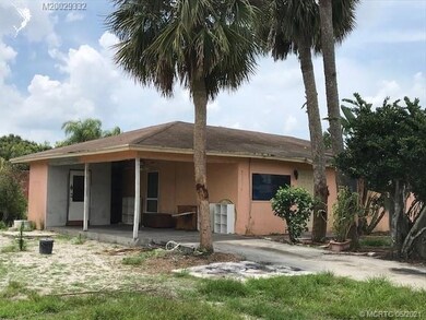 Exterior front with carport & storage room