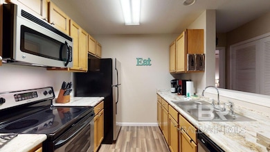 Kitchen with appliances with stainless steel finishes, light countertops, light wood-style flooring, and light brown cabinetry