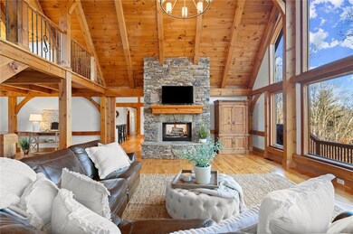 Living room featuring wooden ceiling, high vaulted ceiling, light wood-style floors, baseboards, and beamed ceiling